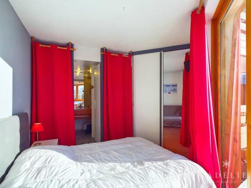 een slaapkamer met rode gordijnen naast een bed bij Charmant 2P avec Parking, Balcon, près des Pistes et Commerces à Montvalezan - FR-1-398-509 in La Rosière