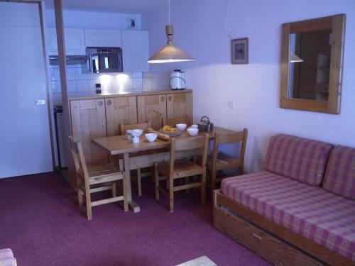 - une cuisine et une salle à manger avec une table et un canapé dans l'établissement Charmant appartement à Méribel avec balcon et accès direct aux pistes - FR-1-355-36, à Méribel