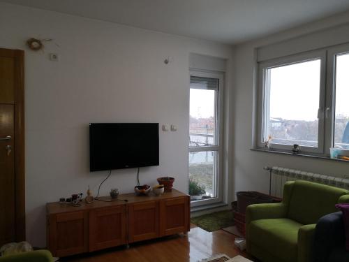 a living room with a flat screen tv on a wall at Apartman17 in Sremska Mitrovica