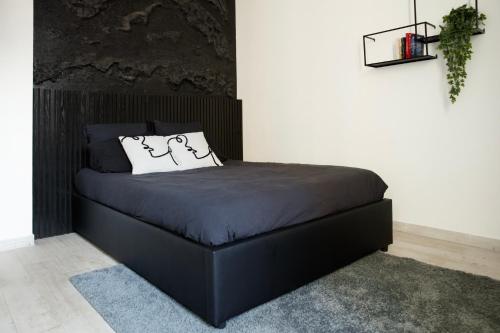 - un lit noir avec tête de lit noire dans la chambre dans l'établissement L'Atelier Contemporain - Porte de Paris, Stade de France, Aéroport CDG, à Aubervilliers