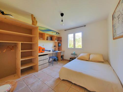une chambre avec un lit et un bureau dans l'établissement La Casa de Mymy 3 chambres Messanges, à Messanges