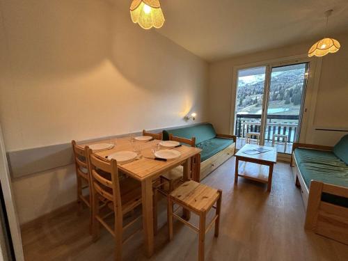 une salle à manger avec une table et des chaises et une fenêtre dans l'établissement Appartement lumineux 2 pièces, parking gratuit, proche des pistes et commerces - 5 pers, SuperDévoluy - FR-1-525-211, à Saint-Étienne-en-Dévoluy