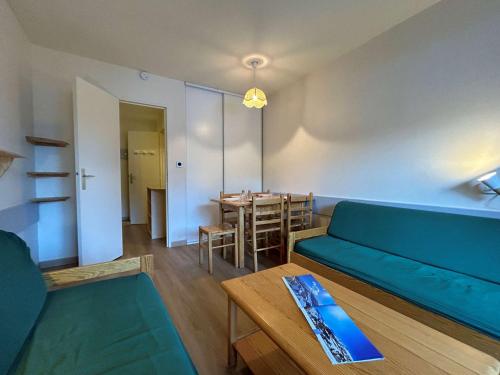 un salon avec un canapé bleu et une table dans l'établissement Appartement lumineux 2 pièces, parking gratuit, proche des pistes et commerces - 5 pers, SuperDévoluy - FR-1-525-211, à Saint-Étienne-en-Dévoluy
