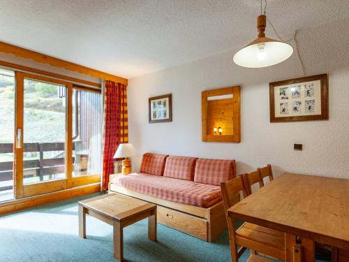 un salon avec un canapé et une table dans l'établissement Appartement avec balcon, proche des pistes et commerces - FR-1-355-203, à Les Allues