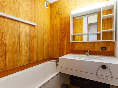 une salle de bain avec un lavabo, une baignoire et un miroir dans l'établissement Appartement avec balcon, proche des pistes et commerces - FR-1-355-203, à Les Allues