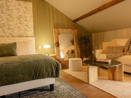a bedroom with a bed and a table and a couch at La Longère de Bourgogne in Demigny