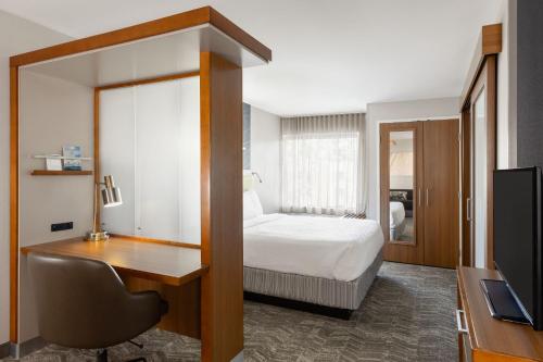 a bedroom with a bed and a desk and a television at SpringHill Suites by Marriott Wisconsin Dells in Wisconsin Dells