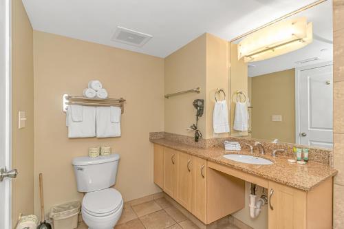 une salle de bain avec toilettes, lavabo et miroir dans l'établissement 1 Bedroom Oceanview Penthouse at Sandy Beach! 1905, à Myrtle Beach