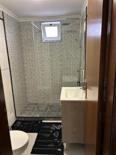 a bathroom with a shower and a toilet and a sink at Caniço Easy Stay in Caniço