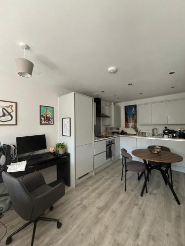 a kitchen with a desk and a table with chairs at Stylish Harbourside Apartment in Bristol