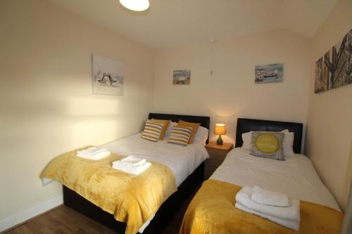 two beds in a small room with at Wellington House in Codnor