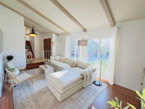 a living room with a white couch and a large window at Del Mar Coastal Haven in San Diego