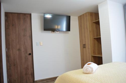 a room with a bed and a television on the wall at Hotel Diamond Luxury Tunja in Tunja