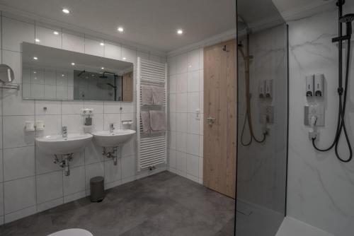 een badkamer met twee wastafels en een glazen douche bij Apart Wiesa in Kappl