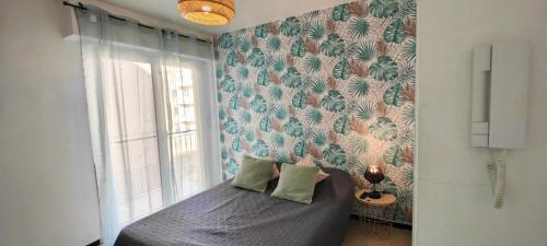 - une chambre dotée d'un lit avec un mur bleu et vert dans l'établissement Cosy studio for 2, à Saint-Raphaël