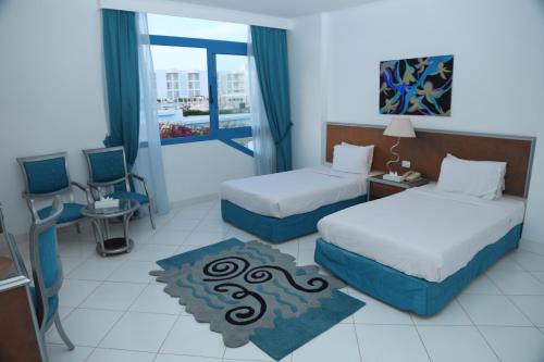 une chambre d'hôtel avec deux lits et un balcon dans l'établissement Amarina Star Resort & Aqua Park Sharm El-Skeikh, à Charm el-Cheikh