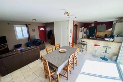 une cuisine et un salon avec une table et des chaises dans l'établissement Bright house with garden near La Rochelle, à Saint-Xandre