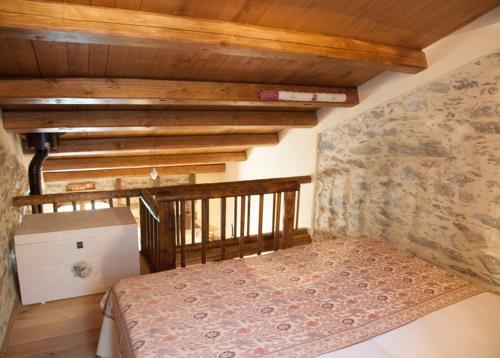 a bedroom with a bed and a stone wall at Il Nettare Agriturismo in Riomaggiore