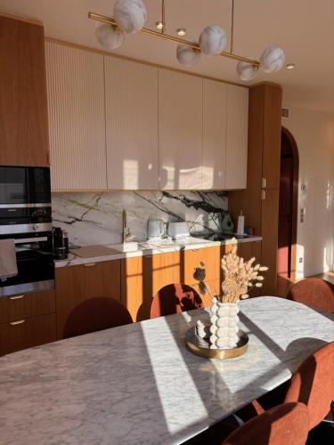 - une cuisine avec une table, des chaises et un comptoir dans l'établissement Superbe appartement Art Déco avec roof top, à Cannes