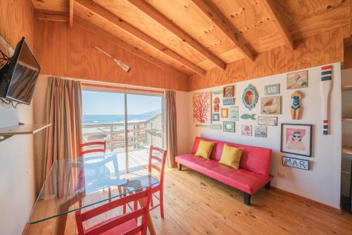 a living room with a red couch and a glass table at Cabaña Ideal in Valparaíso