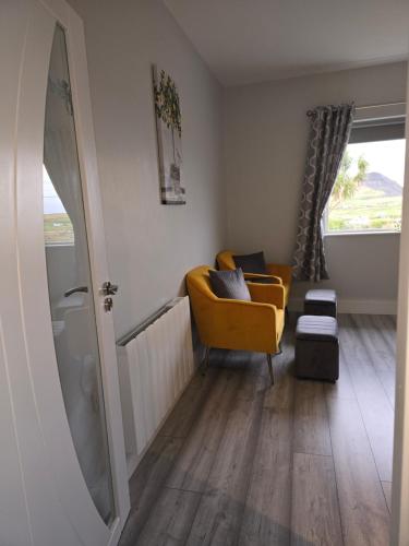 a living room with a yellow chair and a mirror at Cuas view in Dingle