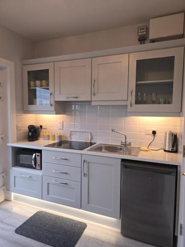 a kitchen with white cabinets and a sink at Cuas view in Dingle