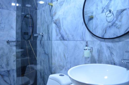 a bathroom with a sink and a mirror and a toilet at Hotel Diamond Luxury Tunja in Tunja
