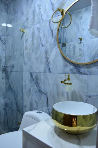 a bathroom with a gold sink on top of a toilet at Hotel Diamond Luxury Tunja in Tunja