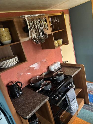 a kitchen with a stove with pots and pans on it at Rubys Happy Haven in Crowle