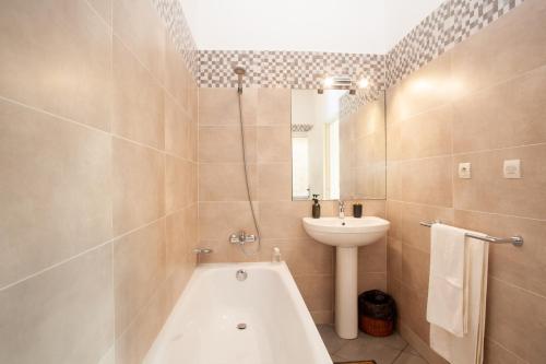 a bathroom with a tub and a sink and a toilet at LAMINA Appart in Antananarivo