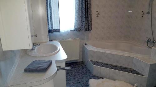 a bathroom with a tub and a sink and a bath tub at Ferienwohnung Kathrin in Mariahof