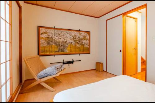 a bedroom with a bed and a chair at 渋谷駅徒歩10分!!一棟まるごと貸し切り!お子様歓迎駐車場無料10人ok5部屋バスルーム2つ in Tokyo