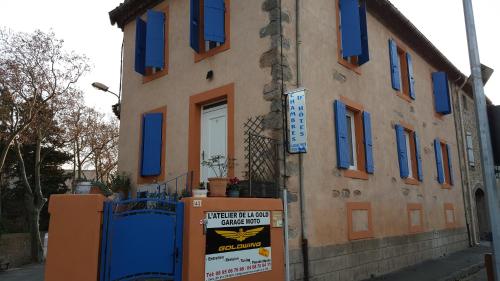 a building with blue windows and a sign in front of it at Millot Conilhac in Conilhac-Corbières