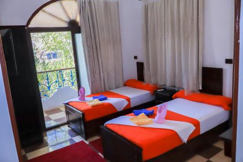 a room with three beds and a window at BAYT ZAINA - Nubian hospitality house in Aswan