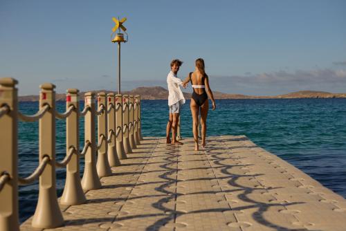 two women standing on a pier near the water at Mykonos Grand Hotel & Resort in Agios Ioannis Mykonos