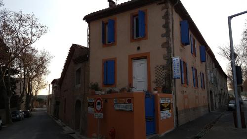 a building with blue windows on a street at Millot Conilhac in Conilhac-Corbières