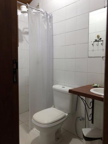a white bathroom with a toilet and a sink at Pousada SerTão de Minas in Conceição da Ibitipoca