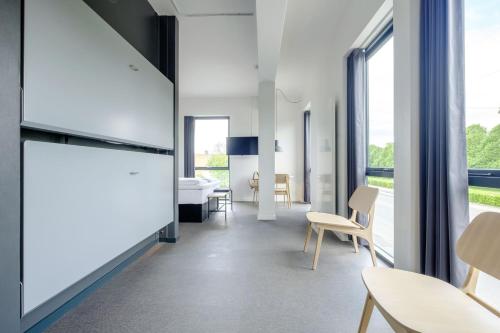 a room with white walls and tables and chairs at Four Points Flex by Sheraton Copenhagen Airport in Copenhagen