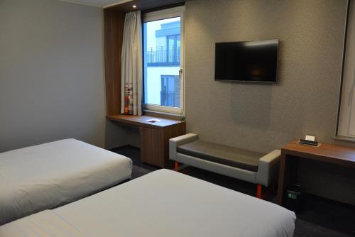 a hotel room with two beds and a television at Aloft Stuttgart in Stuttgart