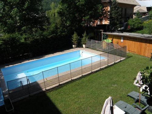 a swimming pool with a fence around it at Hôtel les Vallois in Vallouise
