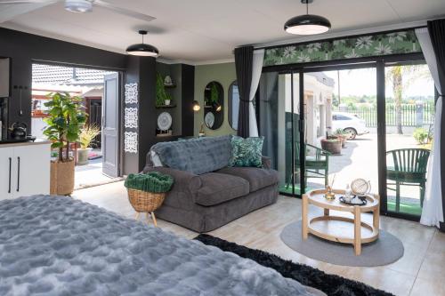 a living room with a couch and a table at Polka Dot Airport Exec Suite in Kempton Park