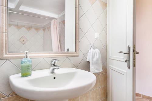 a bathroom with a white sink and a mirror at Paradiso Verde in Lixouri
