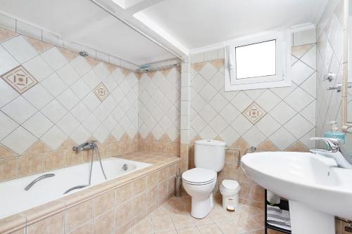 a bathroom with a tub and a toilet and a sink at Paradiso Verde in Lixouri