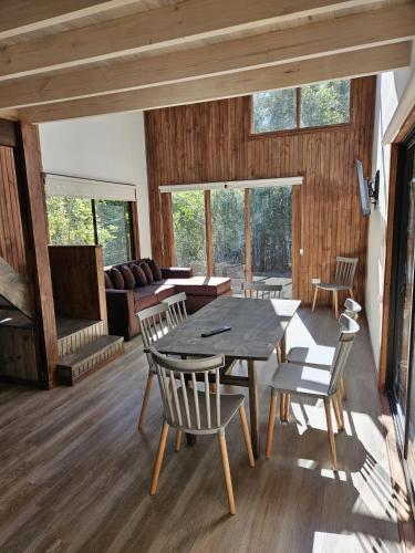 a living room with a table and chairs and a couch at Inspiramide Pucon in Pucón