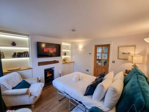 ein Wohnzimmer mit Sofa und Fernseher in der Unterkunft Stunning Cottage in Knutsford by City SuperHost in Knutsford