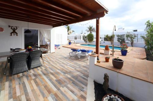 a patio with a table and chairs and a pool at Casa de Suėños in Puerto del Carmen