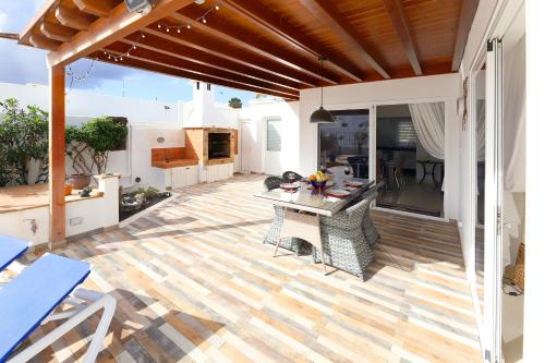 a patio with a table and chairs on a wooden floor at Casa de Suėños in Puerto del Carmen