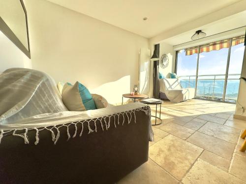 un salon avec un canapé et une grande fenêtre dans l'établissement Les Flots By SCLS Locations, à Cannes