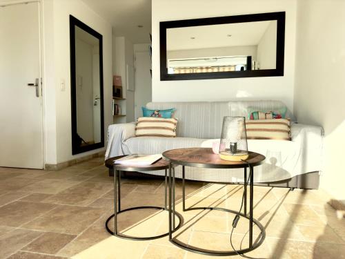 - un salon avec un lit et deux tables dans une pièce dans l'établissement Les Flots By SCLS Locations, à Cannes