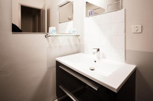 a bathroom with a white sink and a mirror at Le Moulin de Sournia in Sournia